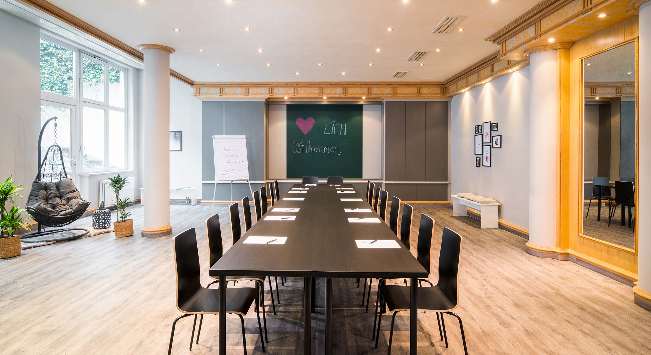 AWA Event Room als lange Tafel für rund sechzehn Personen, mit Tafel und Flipchart